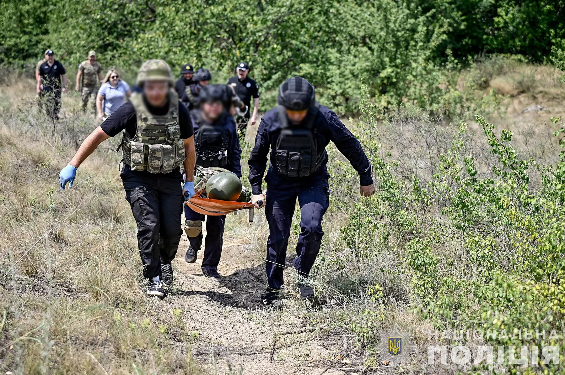 Троє поліцейських під час навчань евакуйовують на ношах умовно пораненого бійця
