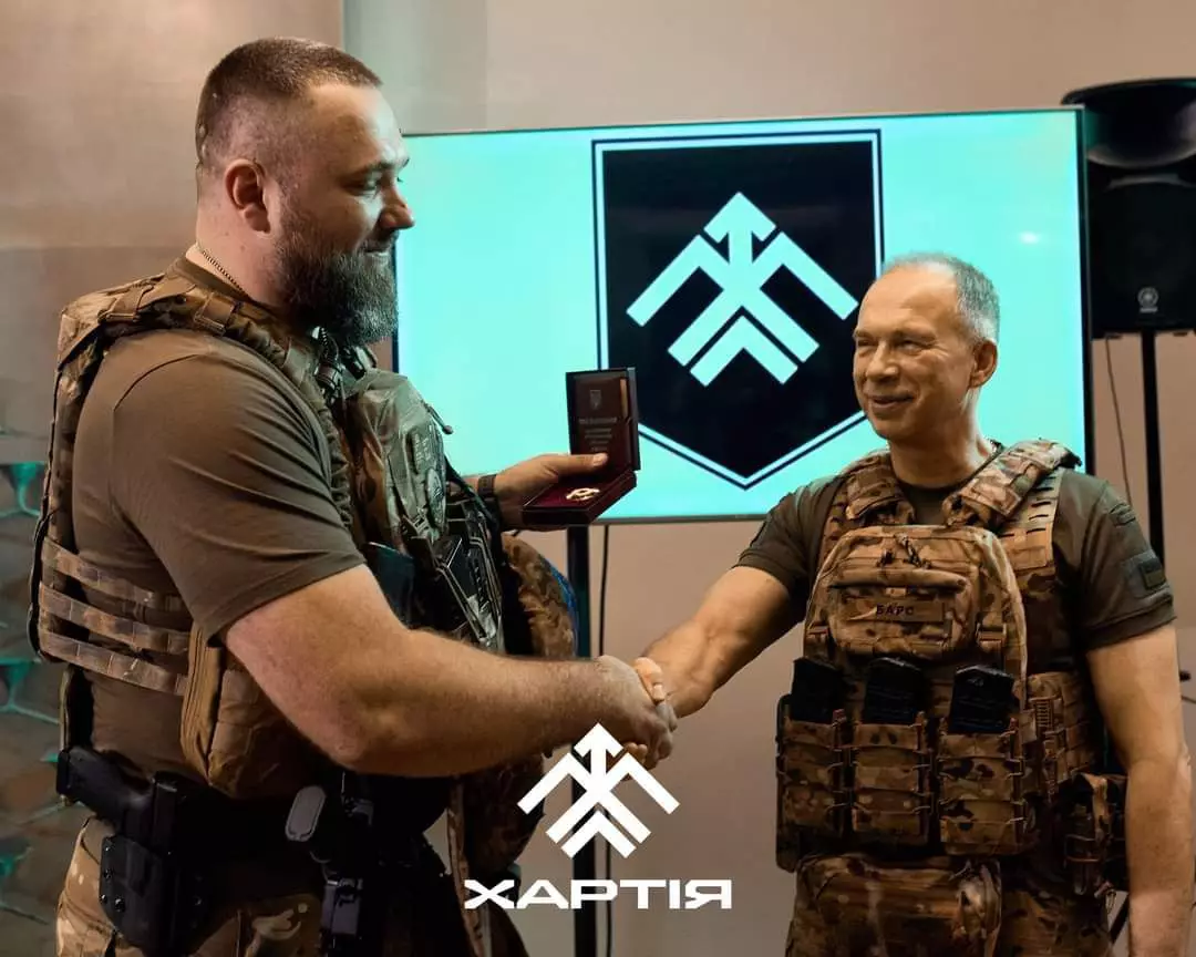 Олександр Сирський тисне руку бійцю, який отримав нагороду