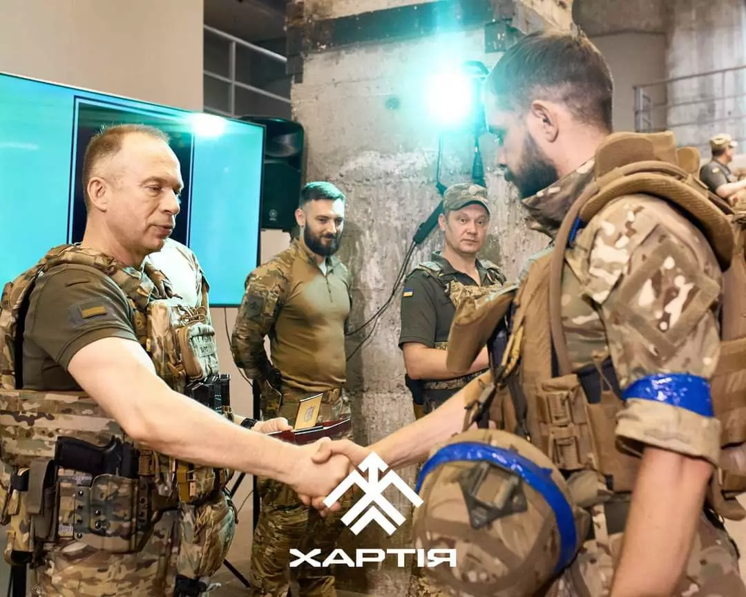 Олександр Сирський тисне руку бійцю бригади "Хартія"