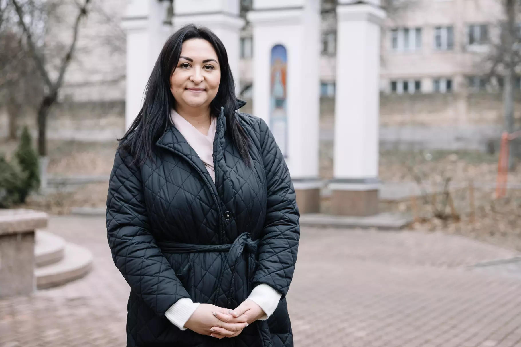 Соціальна супровідниця Сєвда стоїть на подвір'ї медичного закладу