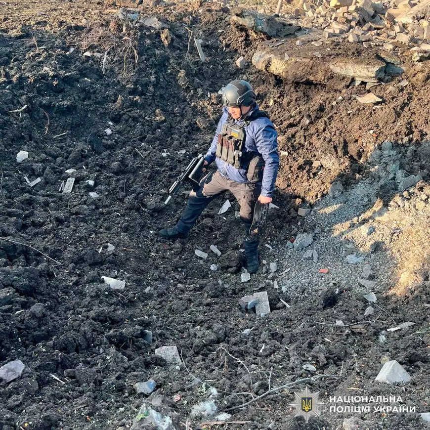 поліцейський оглядає вирву після обстрілу