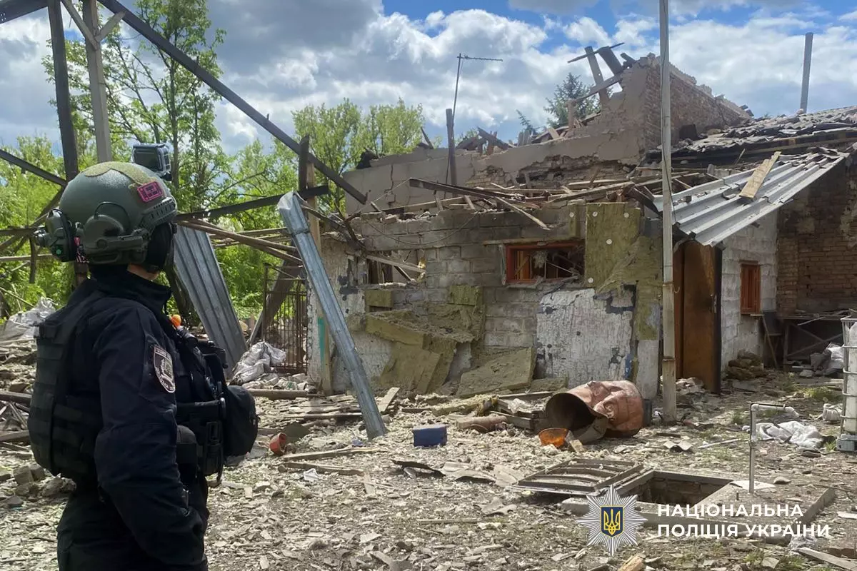 Поліцейський оглядає зруйнований обстрілом будинок